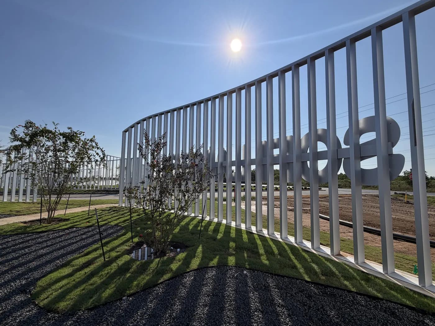 Curved white slat wall with the Sofi letters at the Sofi Lakes entrance in Katy, TX