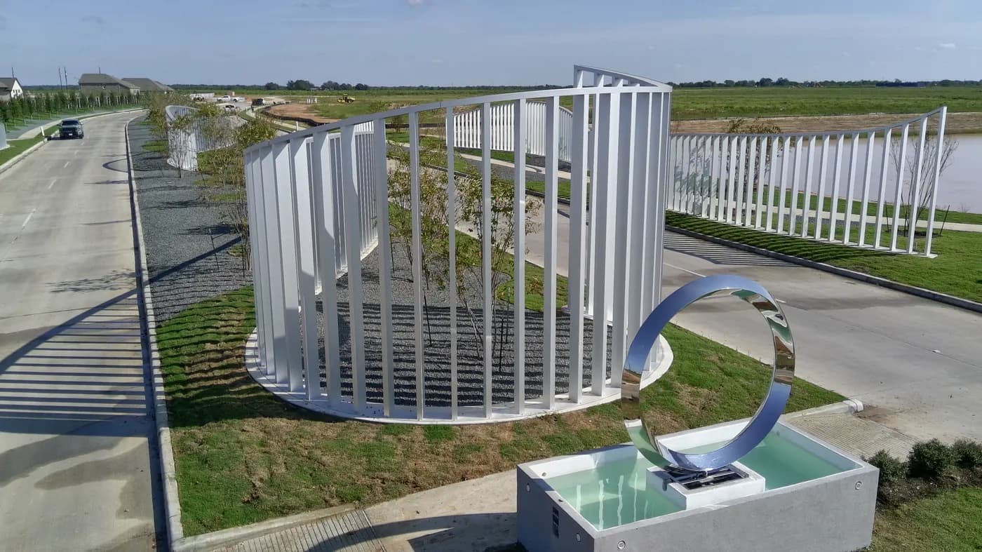 Stainless steel ring sculpture over a water basin at the Sofi Lakes entrance in Katy, TX
